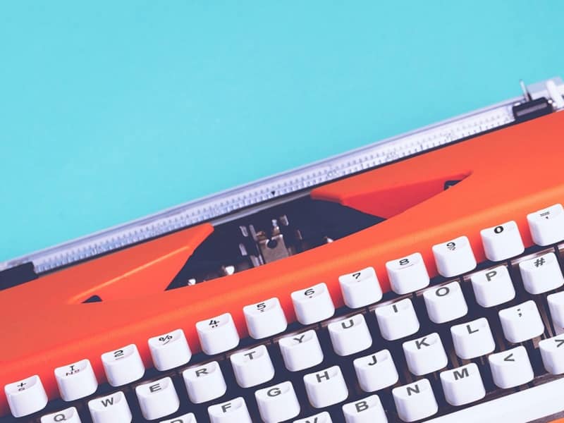 orange typewriter on blue background